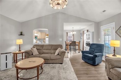 Living room perspective into dining area and kitchen.  Door behind recliner leads to backyard.