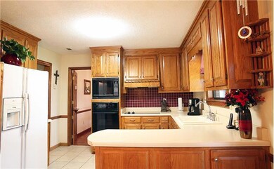 The kitchen features tile flooring, bar with breakfast area, and built in microwave.