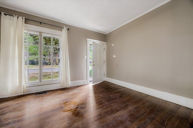 Foyer entrance featuring wood finished floors and crown molding