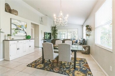 Dining room with vaulted ceiling, a chandelier, and light tile patterned flooring