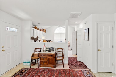 Foyer entrance with light tile patterned floors and a textured ceiling