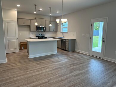 Kitchen featuring backsplash, light wood-type floo