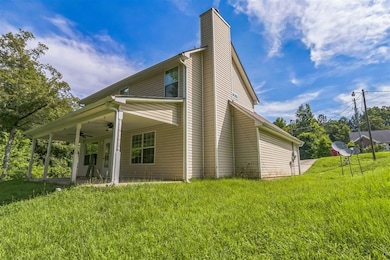 View of property exterior featuring ceiling fan, a chimney, and a yard