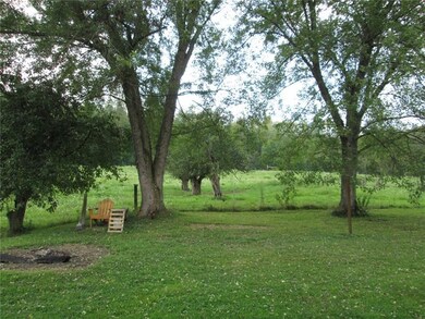 The yard area just behind the home, mature apple t