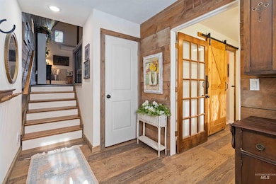 Stairway featuring a barn door and wood finished floors