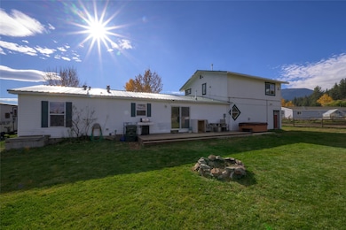 Rear view of house featuring a hot tub, a deck, and a metal roof