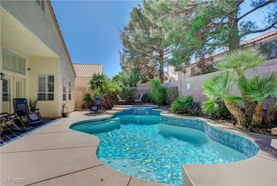 View of swimming pool featuring a fenced backyard, a patio, and a pool with connected hot tub
