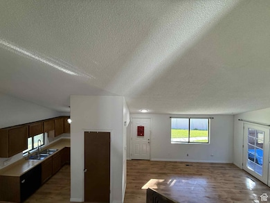 Unfurnished living room featuring wood finished floors and a textured ceiling