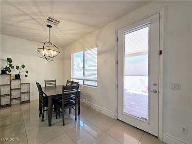 Dining room featuring a chandelier, light tile pat