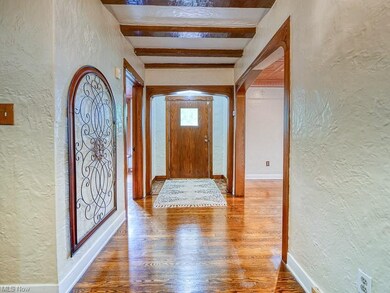 This single story impressive foyer with original flush wood beams on the ceiling, gleaming hardwood solid oak floors and a unique entry door.