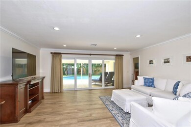 Living area opens to outdoor patio, pool, yard.
