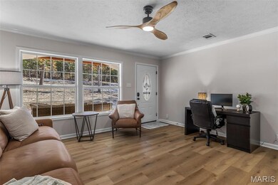 Office area with crown molding, wood finished floors, ceiling fan, and a textured ceiling