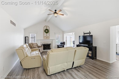 Living area with a high end fireplace, plenty of natural light, and wood finished floors