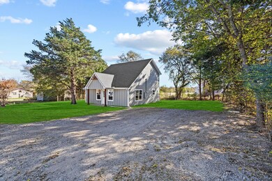 View of side of property with a yard, board and batten siding, driveway, and a shingled roof