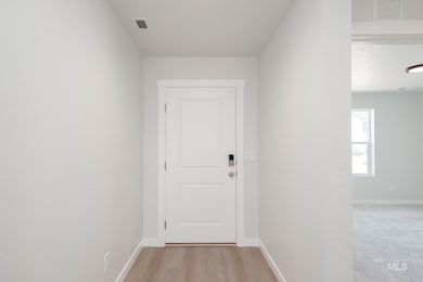 Doorway with baseboards and wood finished floors