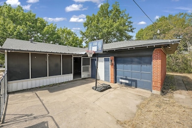 Rear view of property featuring roof with shingles, a sunroom, and brick siding