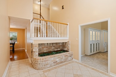 Step inside this spacious, soaring 2-story entryway with a unique built-in planter and bright, welcoming skylight