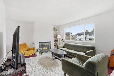 Large open living room with fireplace, lots of natural light and neutral paint.