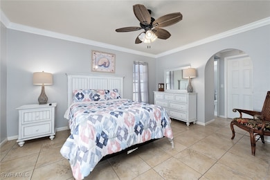 Primary bedroom with ceiling fan, ornamental moldi