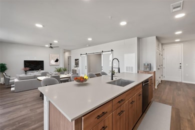 Kitchen with a barn door, a ceiling fan, light co