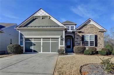 Craftsman-style house featuring driveway, stone si