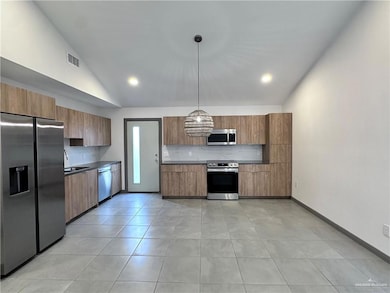 Kitchen with visible vents, decorative backsplash, appliances with stainless steel finishes, and modern cabinets