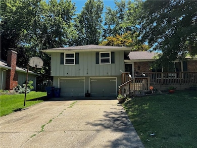 Split level home with a front yard and a garage