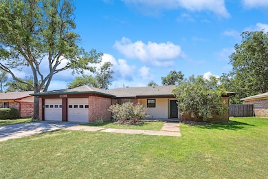 Ranch-style house featuring a front lawn and a gar
