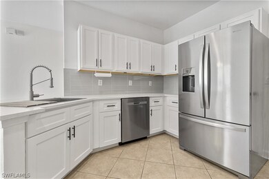 Kitchen with backsplash, light tile floors, sink,