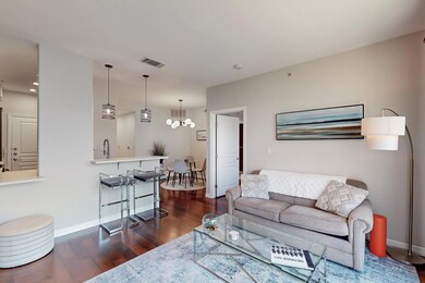 Living area with baseboards, visible vents, a chan