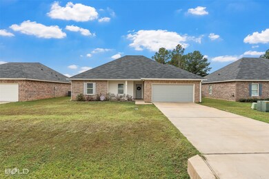 Single story home with a front lawn, concrete driveway, and brick siding