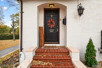 Doorway to property featuring brick siding