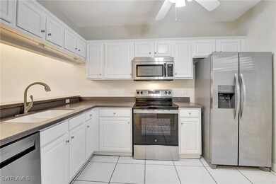 Kitchen with light tile patterned floors, a sink,