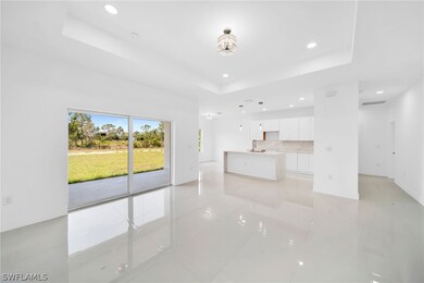 Unfurnished living room featuring sink, a raised ceiling, and light tile patterned floors