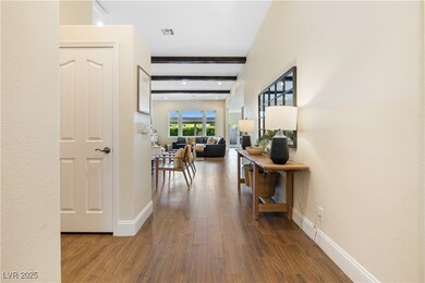Hallway with wood finished floors, beam ceiling, b