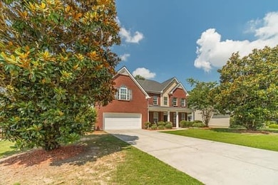 Traditional home with a garage, concrete driveway, and a front lawn
