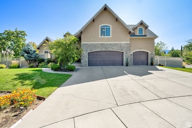 View of front of house with stone siding, stucco siding, a garage, and concrete driveway