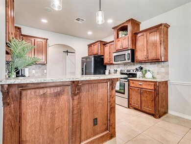 Kitchen featuring gorgeous woodwork, light tile pa