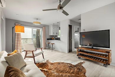Living area featuring a ceiling fan, light wood-s