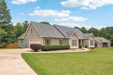 View of front of property featuring concrete driveway, an attached garage, and a front yard