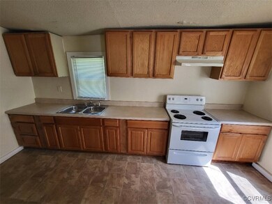 Kitchen with a textured ceiling, electric range, a