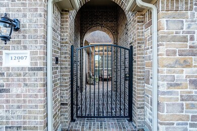 The courtyard gate opens up to a shaded, brick vestibule. The gated courtyard provides privacy and an additional locked entrance at the front of the house. Note the intercom to the left.