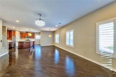 Unfurnished living room with baseboards, dark wood