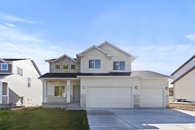 View of front of home featuring board and batten siding, stone siding, concrete driveway, and a front yard.