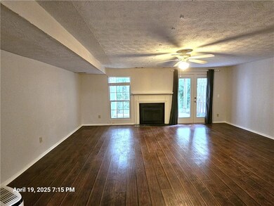 Unfurnished living room featuring baseboards, a fi