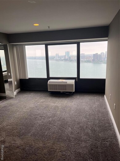 Carpeted empty room featuring plenty of natural light and a city view