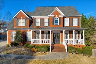 View of front of house featuring covered porch, a shingled roof, and brick siding