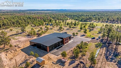 Aerial view of property and surrounding area featuring a heavily wooded area
