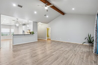 Unfurnished living room featuring beamed ceiling, high vaulted ceiling, ceiling fan, and light hardwood / wood-style flooring