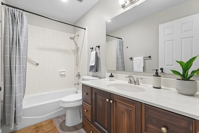 Full bath with vanity, light wood-style flooring, and shower / tub combo with curtain